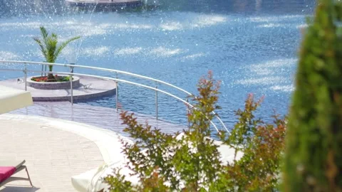 Poolside area with lounge chairs, greenery, and umbrellas, offering a peace.. Stock Footage 293122720