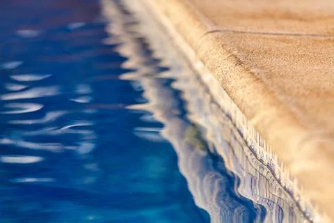 Poolside with clear blue water Stock Photos