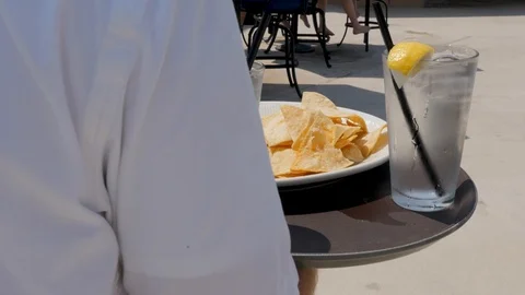 Poolside service chips and salsa to table of people Stock Footage 94232285