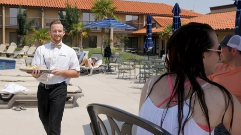 Poolside service man brings chips salsa to table of people 스톡 동영상 94232839