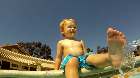 Poolside Splash: Boy Kicking Water in Summer Stock Footage 8945194