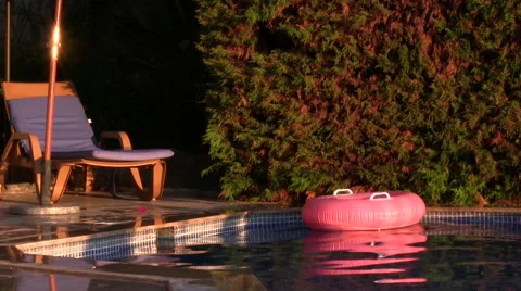 Poolside view inflatable floats, sun lounger in foreground Stock Footage 41256252