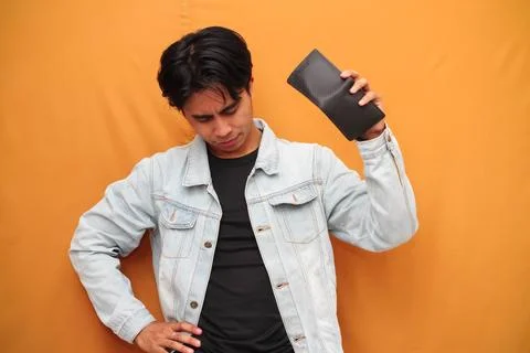 Poor Asian man posing holding empty wallet, Asian man holding empty wallet .. Stock Photos