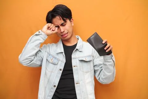 Poor Asian man posing holding empty wallet, Asian man holding empty wallet .. Stock Photos
