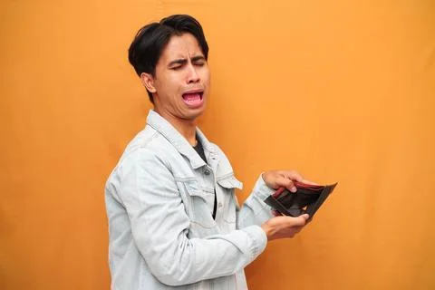 Poor Asian man posing holding empty wallet, Asian man holding empty wallet .. Stock Photos