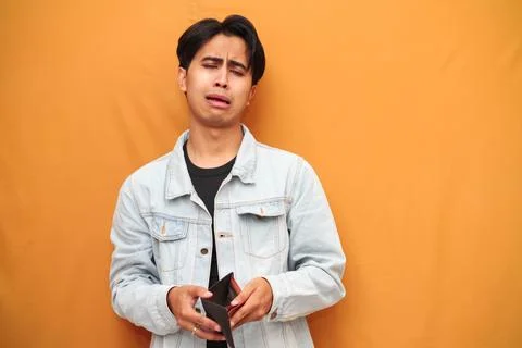 Poor Asian man posing holding empty wallet, Asian man holding empty wallet .. Stock Photos