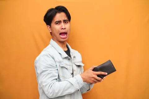Poor Asian man posing holding empty wallet, Asian man holding empty wallet .. Stock Photos