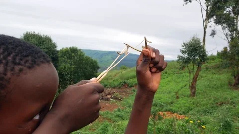 Poor black child playing with a catapult Stock Footage 72306312