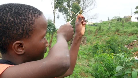 Poor black child playing with a catapult 스톡 동영상 72306320