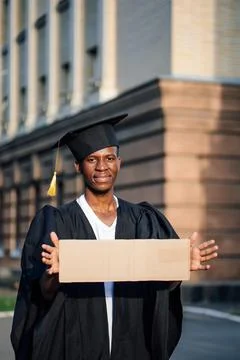 Poor black guy standing with cardboard sign on street looking for job Stock Photos