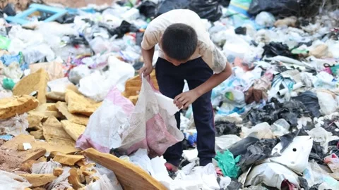 A poor boy collecting garbage waste from a landfill site in the outskirts ... Stock Footage 336937377