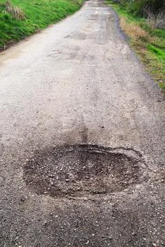 Poor condition of the road surface. Spring season. Hole in the asphalt Stock Photos
