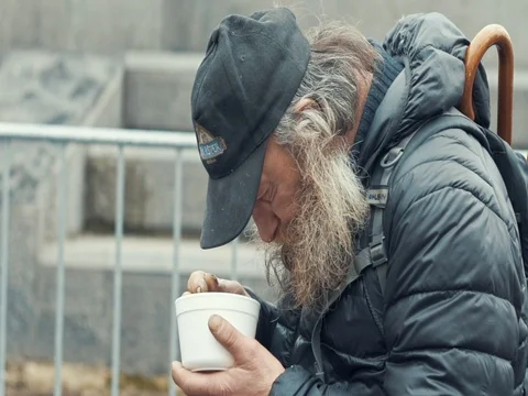 Poor homeless with beard eating soup from plastic plates Stock Footage