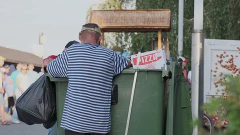 Poor Hungry Homeless Men Rummage in Garbage Cans Searching for Food Stock Footage 136250867