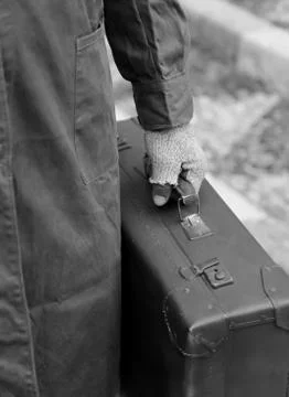 Poor immigrant with old leather suitcase and broken gloves in winter  with bl Stock Photos
