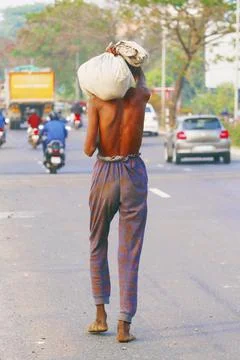 Poor indian man walking with bare foot on a street Stock Photos