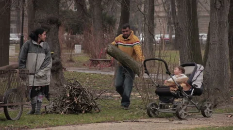 Poor male and female gypsy putting firewood in trolley. Baby in stroller.Poverty Stock Footage