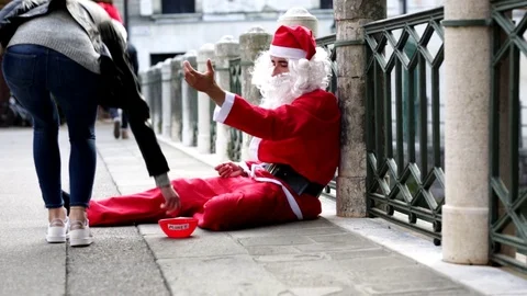 The poor man dressed as Santa begs for alm Stock Footage 118249528