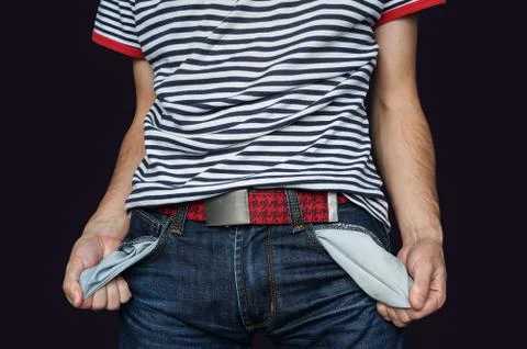 Poor man in jeans with empty pocket isolated on black Foto stock