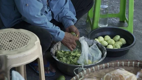 Poor man peeling mangoes Stock Footage 125497402