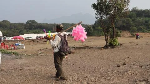 A poor man selling cotton candy to the children. Stock Photos