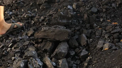 A poor middle-aged man crushes coal with his hands in a quarry for sale to Video stock 100429641
