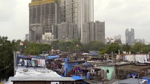 Poor Mumbai slum, huge skyscraper construction in background, India Stock Footage 74905581