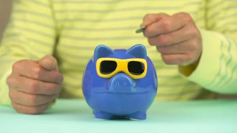 Poor old man throws coins into money box of pig form slot Video stock 132703883