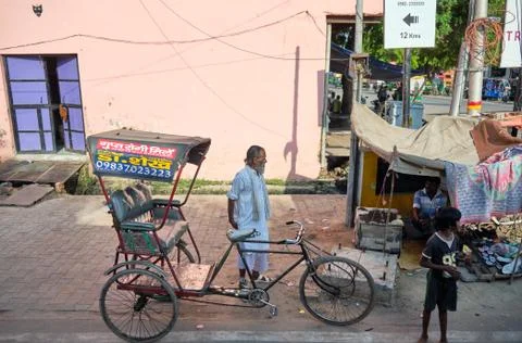 Poor old rickshaw driver with his bicycle rickshaw in Agra, Uttar Pradesh, In Stock Photos