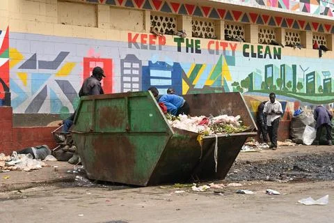 Poor people rummage through a container of food waste at the central market.. 写真素材