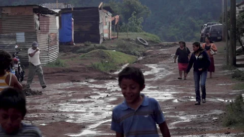 Poor people walking on a dirt road in a slum of Guatemala City Stock Footage 146011956