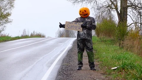Poor pumpkinhead try to hitch ride back to summer, stay with written sign Stock Footage