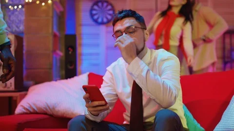 Poor stressed bearded business guy getting bored on night party. He is using Stock Footage 122937295