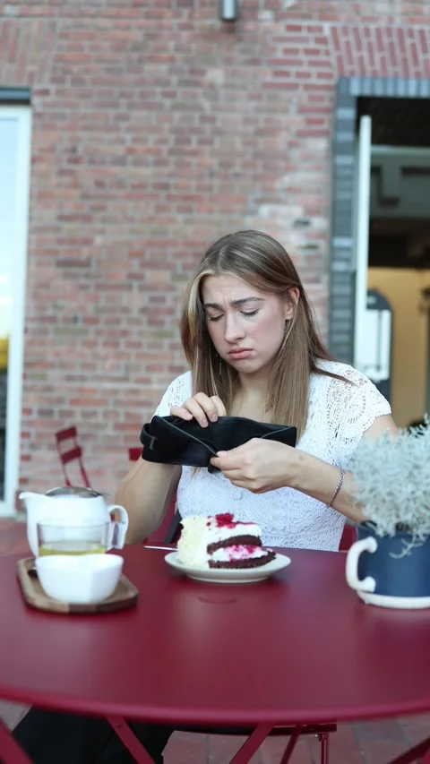Poor student realizes she spent her last money on dessert at a cafe Stock Footage 344448336