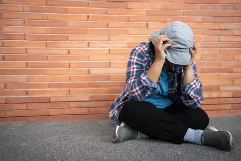 Poor tired stressed depressed elderly Asian woman homeless sitting on the s.. Stock Photos
