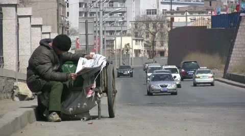 Poor worker reads newspaper along the road in China Vídeos de archivo 8507298