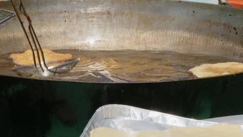 Poori puff bread fries in vat of oil at outdoor Indian food festival Video stock 335125663