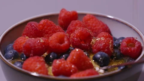 Pooring honey on some berries. Stock Footage 336723861