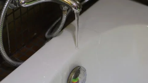 A poorly designed faucet with water streaming outside the bathtub, highligh.. Stock Footage 293124491