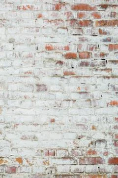 Poorly painted wall of damaged red brick with white paint, textu Stock Photos