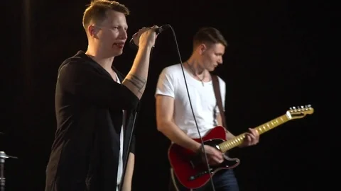 Pop band with a singer and musicians performing in a dark studio Stock Footage