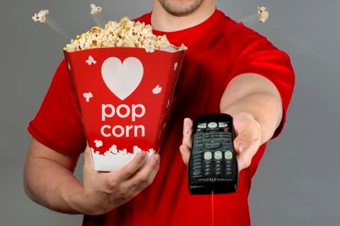 Pop corn and remote control. Stock Photos