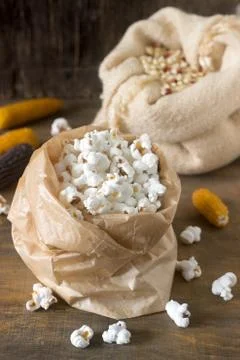 Pop corn, corn grain and cobs on a wooden background. Rustic style, selective Stock Photos