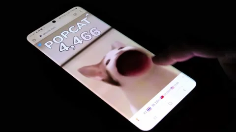 Popcat game being played by tapping finger on cat on modern smartphone Stock Footage 158935572