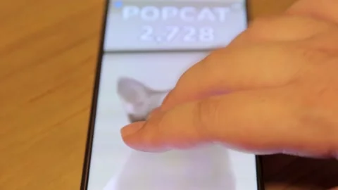 Popcat game being played by tapping finger on cat on modern smartphone Stock Footage 158935634