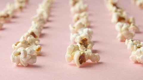 Popcorn arranged in order with a pattern on light pink background Fotos de archivo