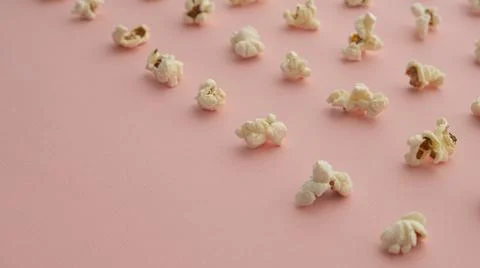 Popcorn arranged in order with a pattern on light pink background Stock Photos