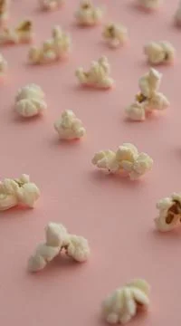 Popcorn arranged in order with a pattern on light pink background Stock Photos