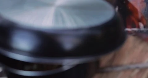 Popcorn being cooked on open fire in saucepan in slow motion Stock Footage 98271963