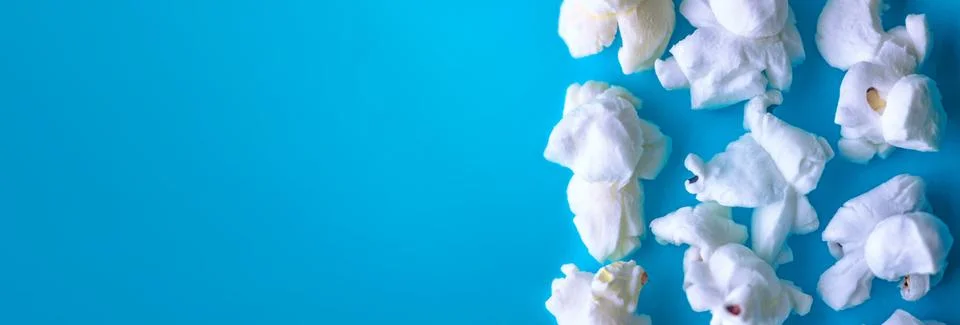Popcorn on a blue background. Macro image of popcorn. Place for your text Stock Photos